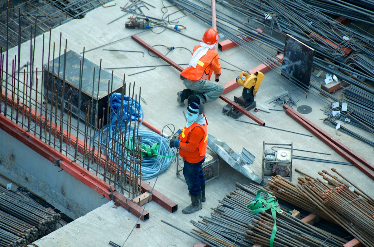 Construction professionals preparing structural steel on a building site